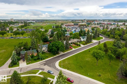 Aerial perspective showcasing a developed urban area with expansive green spaces, residential properties, and commercial buildings - 11022 110 Avenue, Edmonton, AB 