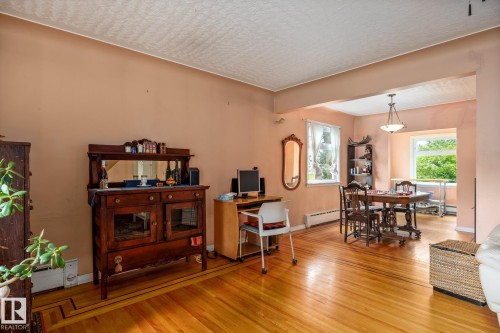 Hardwood flooring with a patterned inlay detail throughout this open-concept room - 11022 110 Avenue, Edmonton, AB 