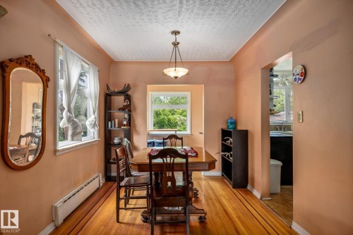 Hardwood flooring with inlaid borders, multiple windows, and a ceiling-mounted light fixture - 11022 110 Avenue, Edmonton, AB 