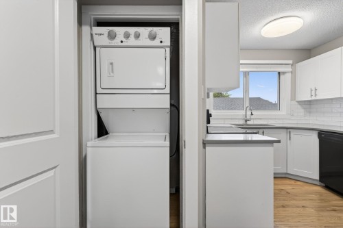 Laundry closet featuring a white stackable washer and dryer - 15112 80 Street, Edmonton, AB 