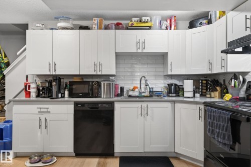 White shaker cabinetry with brushed nickel hardware, subway tile backsplash, and light-toned countertops - 15112 80 Street, Edmonton, AB 