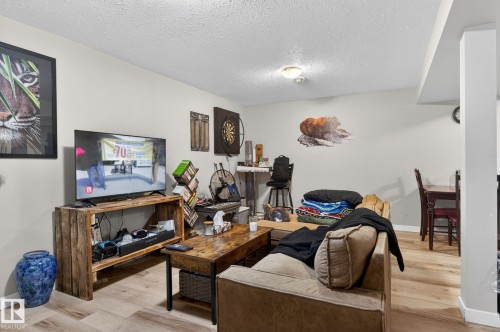 Open-concept living space featuring light wood-finish flooring, recessed ceiling lighting, and neutral wall tones - 15112 80 Street, Edmonton, AB 