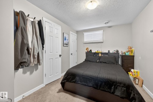 Bedroom featuring a textured ceiling, neutral wall paint, and carpet flooring - 15112 80 Street, Edmonton, AB 