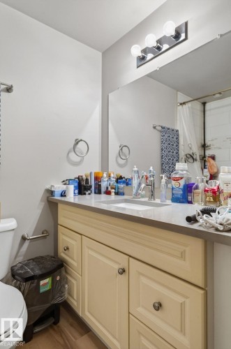 Bathroom vanity featuring a light-toned countertop, an integrated sink, and classic cabinetry with knob hardware - 15112 80 Street, Edmonton, AB 