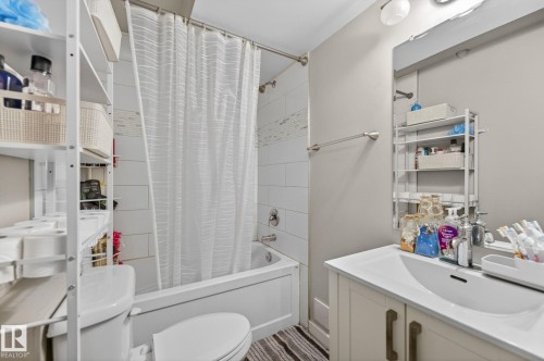 Bathroom featuring a white bathtub with subway tile surround and decorative accent tile - 15112 80 Street, Edmonton, AB 