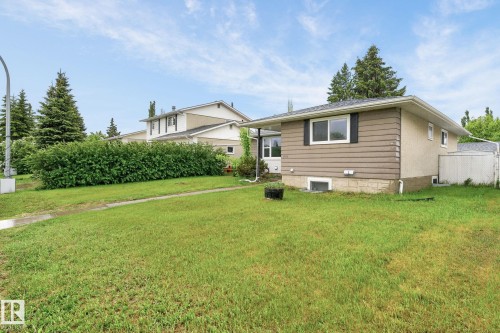Exterior features include a brown horizontal siding facade, white-trimmed windows with dark shutters, and a grey shingle roof - 15112 80 Street, Edmonton, AB 