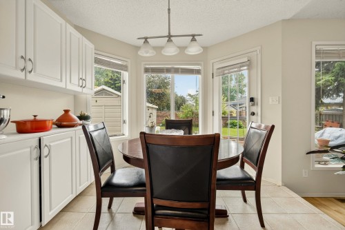 Bright dining area featuring a bay window, a full-lite exterior door, and tile flooring - 9 Emerald Terrace, St. Albert, AB 