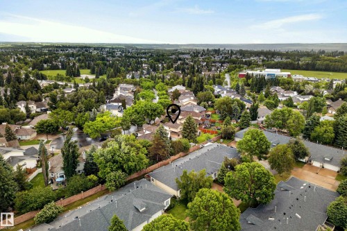 Aerial perspective showcasing a residential area with varied housing styles and mature tree coverage - 9 Emerald Terrace, St. Albert, AB 