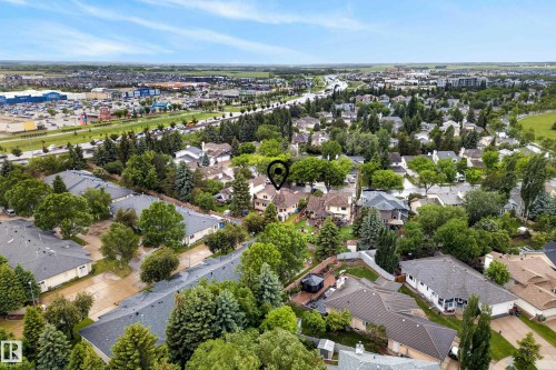 Aerial perspective showcasing a residential area with varied rooflines and extensive tree canopy - 9 Emerald Terrace, St. Albert, AB 