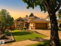 Single-story residence featuring a prominent bay window with multiple panes, an attached garage with a brown door, and a textured stucco exterior - 9 Emerald Terrace, St. Albert, AB 