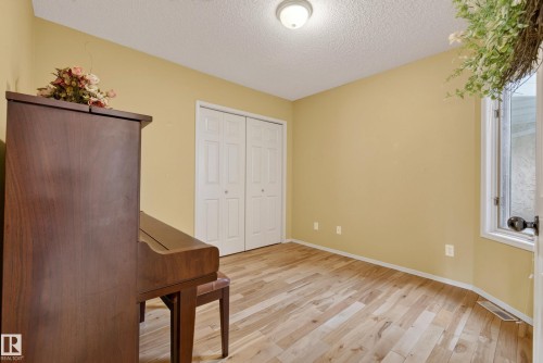 Room featuring wood-finish flooring, light yellow walls, and a white ceiling - 9 Emerald Terrace, St. Albert, AB 