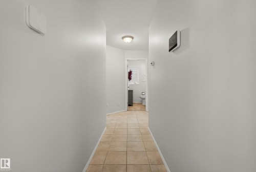 Hallway with light-colored tile flooring and neutral wall tones - 9 Emerald Terrace, St. Albert, AB 