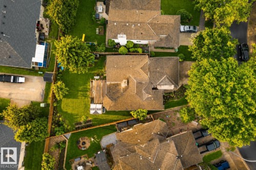 Expansive property featuring a multi-level roofline, mature trees, a manicured lawn, and a paved driveway - 9 Emerald Terrace, St. Albert, AB 