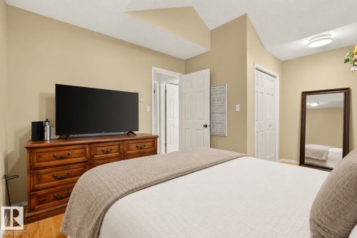 Warm-toned walls complement wood-finish flooring in this bedroom space - 9 Emerald Terrace, St. Albert, AB 