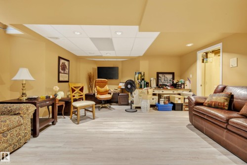 Finished basement room featuring wood-finish flooring, recessed lighting, and a drop ceiling - 9 Emerald Terrace, St. Albert, AB 