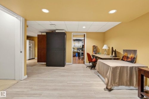 Spacious room featuring light wood-finish flooring, recessed lighting, and a neutral wall color - 9 Emerald Terrace, St. Albert, AB 