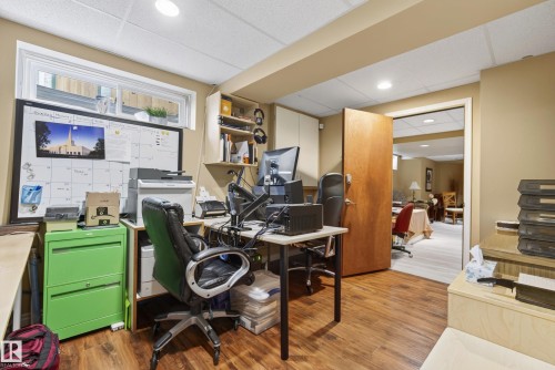 Wood-finish flooring throughout this versatile space featuring a window, recessed lighting, and an open doorway revealing additional finished areas - 9 Emerald Terrace, St. Albert, AB 