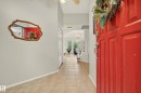 Entryway featuring a paneled red door, tile flooring, and light gray walls - 9 Emerald Terrace, St. Albert, AB 