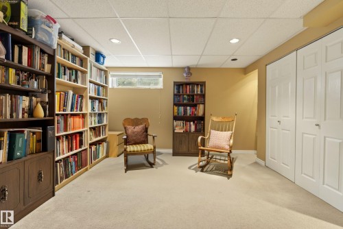 Finished room featuring extensive built-in shelving, soft neutral carpeting, recessed ceiling lighting, and a bi-fold door closet - 9 Emerald Terrace, St. Albert, AB 