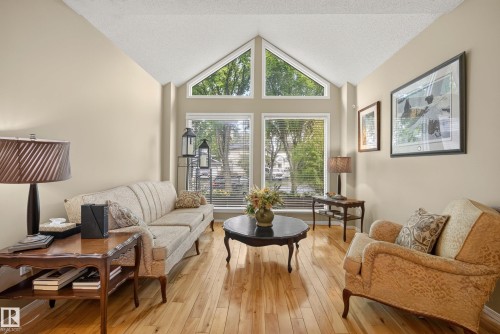 Living area featuring vaulted ceilings, light wood-finish flooring, and large windows with transom architectural details - 9 Emerald Terrace, St. Albert, AB 