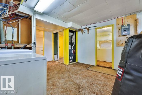 Utility space featuring carpet flooring, exposed wall studs, and a visible electrical panel - 8318 80 Avenue, Edmonton, AB 