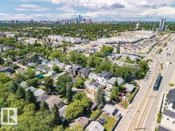 Aerial perspective showcasing a residential neighborhood with mature trees, a commercial center, and a distant city skyline - 