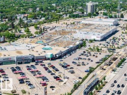 Expansive commercial complex featuring multiple retail establishments, extensive surface parking, and direct access to a light rail transit line - 