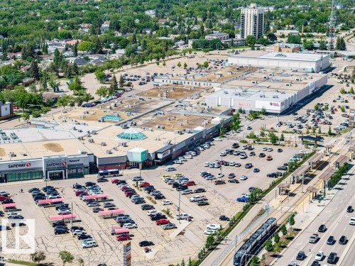 Expansive commercial complex featuring multiple retail establishments, extensive surface parking, and direct access to a light rail transit line - 8318 80 Avenue Nw, Edmonton, AB - Outdoor With View