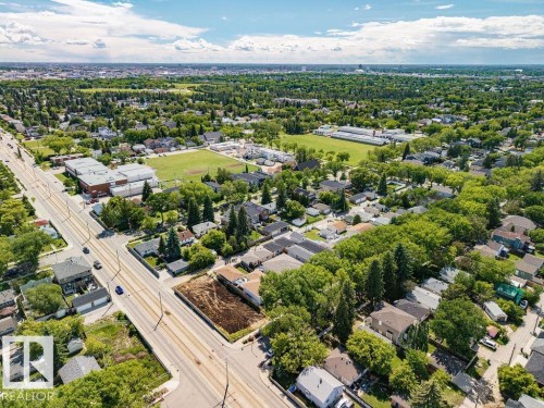 Aerial perspective showcasing a residential area with mature tree canopies, paved roadways, and a large green space - 8318 80 Avenue Nw, Edmonton, AB - Outdoor With View