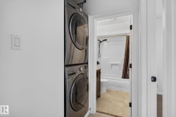 Stackable washer and dryer appliances with a white wall-mounted light switch - 