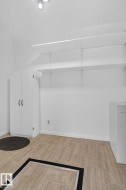Utility room featuring light-toned tile flooring, white built-in cabinetry, adjustable shelving, and a surface-mounted ceiling light fixture - 