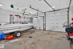 Spacious garage featuring concrete flooring and two overhead doors - 