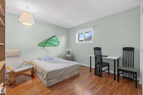 Bedroom featuring wood-finish flooring, a single window, and light-colored walls - 10935 152 Street, Edmonton, AB 