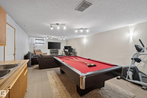 Spacious recreational area featuring a red felt billiards table - 10935 152 Street, Edmonton, AB 