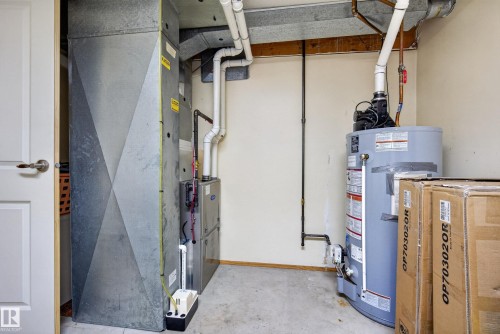 Dedicated utility area featuring a furnace system, water heater, and associated plumbing - 10935 152 Street, Edmonton, AB 