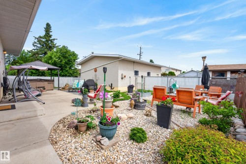 Outdoor living area featuring a concrete patio, gravel landscaping, and a built-in hot tub under a gazebo - 10935 152 Street, Edmonton, AB 