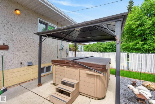 Outdoor spa under a metal gazebo, set on a concrete patio - 10935 152 Street, Edmonton, AB 