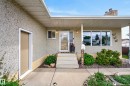 Stucco exterior with a covered porch entrance and concrete steps - 10935 152 Street, Edmonton, AB 