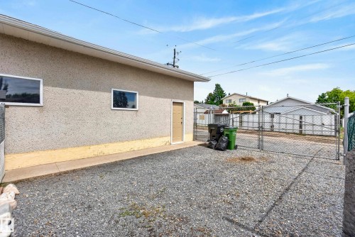 Exterior building featuring stucco siding, two horizontal windows, and a side entry door - 10935 152 Street, Edmonton, AB 