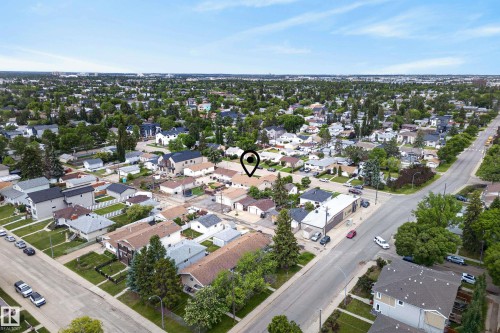 Residential neighborhood featuring a mix of single-family homes and multi-story dwellings, established street grid, abundant mature trees, and clear sky conditions - 10935 152 Street, Edmonton, AB 
