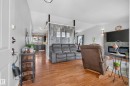 Open-concept living area with wood-finish flooring, vaulted ceilings, and a gray shiplap accent wall - 10935 152 Street, Edmonton, AB 
