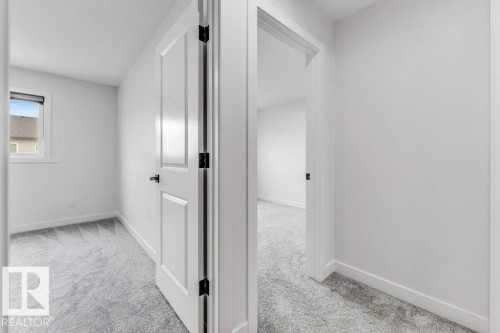 White paneled interior door with black hardware, complementing light gray carpeting - 423 28 Street, Edmonton, AB 