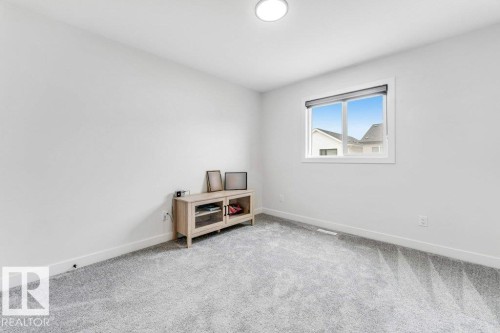 Room featuring light gray carpeting, crisp white walls, a single window with a roller shade, and a flush-mount ceiling light fixture - 423 28 Street, Edmonton, AB 