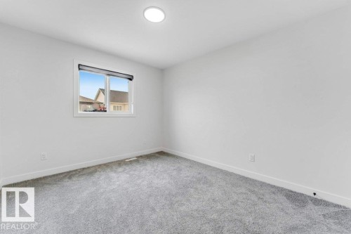 Room featuring light gray carpeting, white walls, and a recessed ceiling light - 423 28 Street, Edmonton, AB 