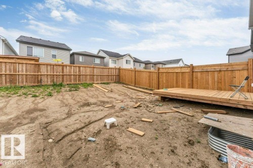 Expansive backyard area featuring a wood fence, a newly constructed wood deck, and a window well - 423 28 Street, Edmonton, AB 