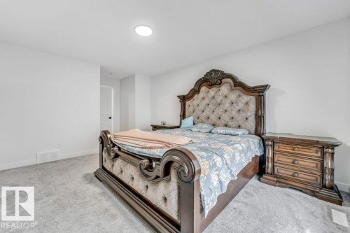 Spacious bedroom featuring light grey carpet flooring, recessed ceiling lighting, and a white interior door - 423 28 Street, Edmonton, AB 