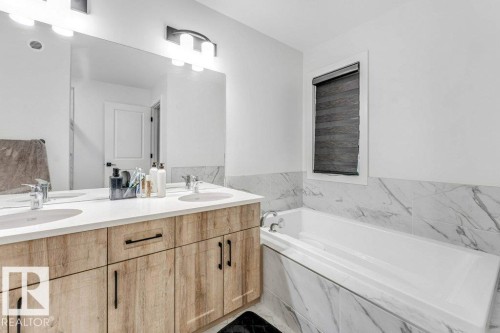 Bathroom featuring a dual vanity with light wood-finish cabinetry and white countertops - 423 28 Street, Edmonton, AB 