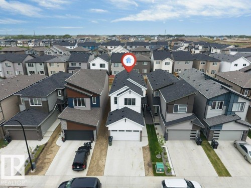Contemporary multi-story residence featuring a white facade and dark trim - 423 28 Street, Edmonton, AB 