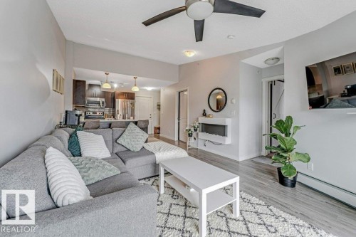 Open-concept living area featuring wood-finish flooring and a ceiling fan - 401 667 Watt Boulevard, Edmonton, AB 