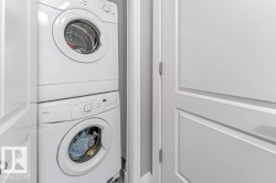 Compact laundry area featuring a stacked washer and dryer unit - 